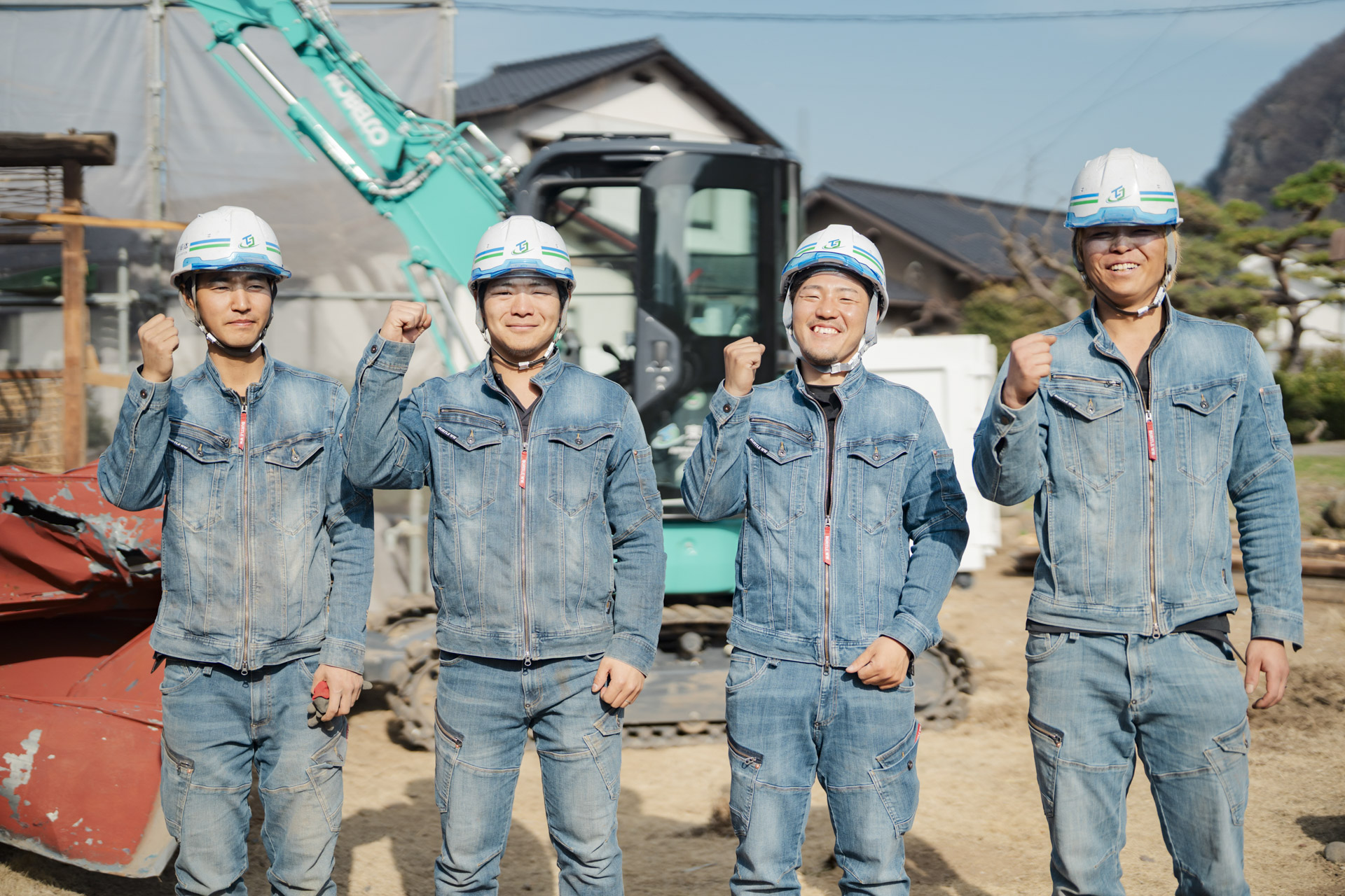 代表を含めた4人の作業員の方たちのガッツポーズをして笑顔の写真